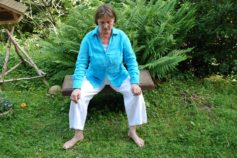 Ich mache die Übung barfuß, damit ich den Boden unter den Füßen spüre.